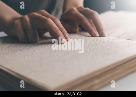 Blinder Mann liest den Text eines Braillebuches. Stockfoto