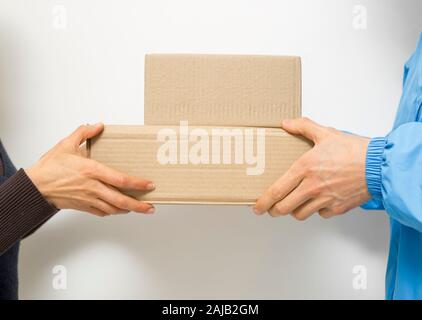Der Kurier gibt dem Kunden Lieferboxen. Stockfoto