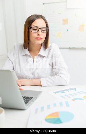Porträt eines lächelnden Frau Finanzier an einem Computer arbeiten. Stockfoto