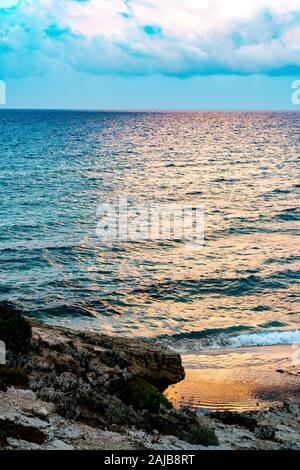 Steinige Küste am Abend Stockfoto
