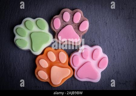Cute farbige paw Form Seife auf dunklen dunklen Hintergrund Stockfoto