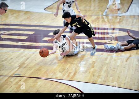 Gegnerische Spieler kriechen auf dem Boden in einer Bemühung, eine lose Kugel zu sichern. USA. Stockfoto