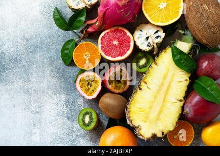 Exotische Asien Obst Hintergrund. Sortierte reif saftig tropischer Sommer Obst der Saison auf einem grauen Stein. Ansicht von oben flach Hintergrund. Stockfoto