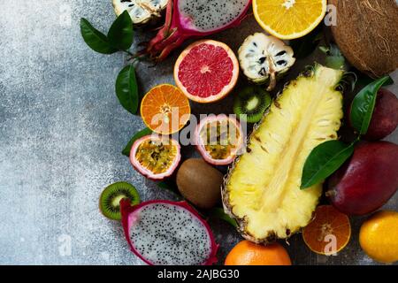 Exotische Asien Obst Hintergrund. Sortierte reif saftig tropischer Sommer Obst der Saison auf einem grauen Stein. Ansicht von oben flach Hintergrund. Stockfoto