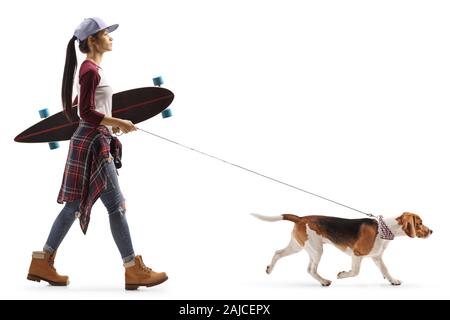 Volle Länge Profil Schuß eines weiblichen Teenager mit einem Skateboard zu Fuß einen Hund auf weißem Hintergrund Stockfoto