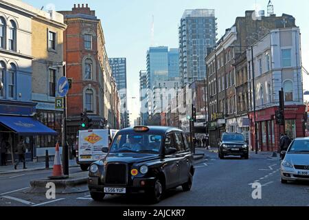 Schwarzes Taxi auf der Commercial Street in Spitalfields Verkehr Im East End London E1 England GB KATHY DEWITT Stockfoto