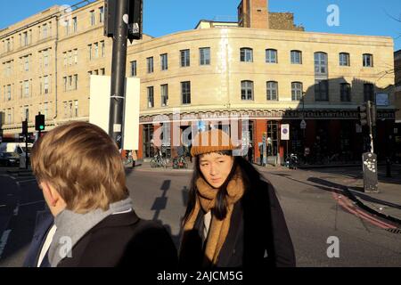 Alle Heiligen Fashion Designer Clothing Store und junge chinesische Frau Kreuzung Commercial street in Spitalfields East London E1 England UK KATHY DEWITT Stockfoto