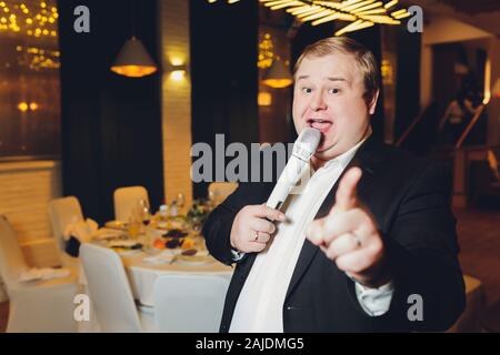 Charmante junge Mann wirkt am Abend Konzert in einem grauen Anzug im Licht der Scheinwerfer Stockfoto