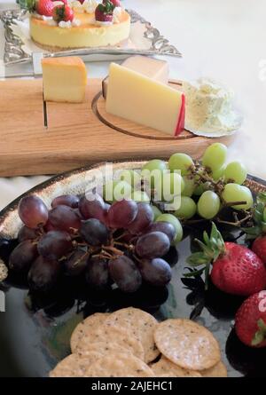 Teller mit Obst, Kekse, Käse und eine Erdbeere überstieg Käsekuchen, für hungrige Menschen auf ein Ereignis eingestellt Stockfoto
