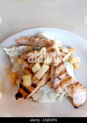 Gegrillte Lachsfilets ruhen auf Knoblauch Kartoffelpüree und gekrönt mit Apple Stücke Stockfoto