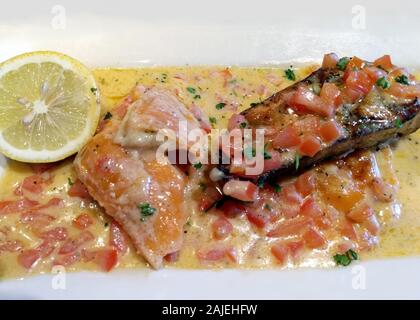 Rinderfilet Steak mit gesunden Lachs, mit gewürfelten Tomaten und eine cremige Knoblauchbutter gekrönt Stockfoto