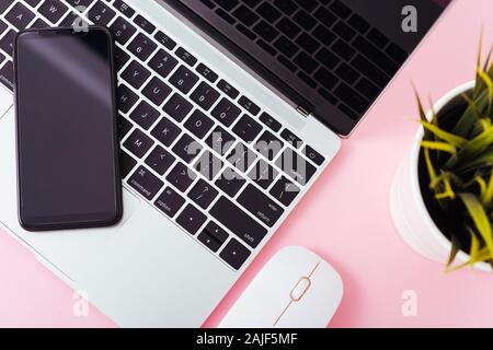 Blick von oben auf die moderne Technologie smart phone mobile und Computer Laptop auf rosa Hintergrund mit Kopie Raum Stockfoto