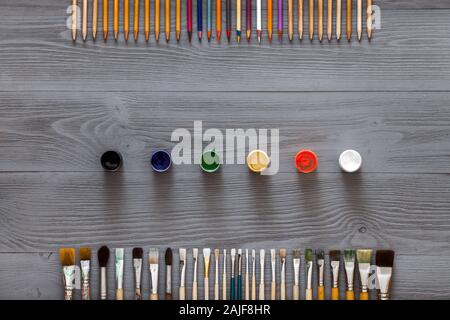 Art kreativ Tabelle Hintergrund mit Zubehör Werkzeuge auf grau Schreibtisch aus Holz Stockfoto