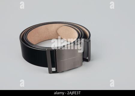 Schwarzer Ledergürtel isoliert auf grauem Hintergrund Stockfoto