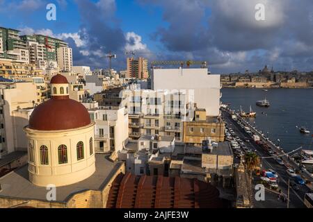 Stadt Sliema in Malta, Stadtbild mit Mehrfamilienhäusern und Kuppel der Pfarrkirche von Jesus von Nazareth, den Hafen von Marsamxett auf der rechten Seite. Stockfoto