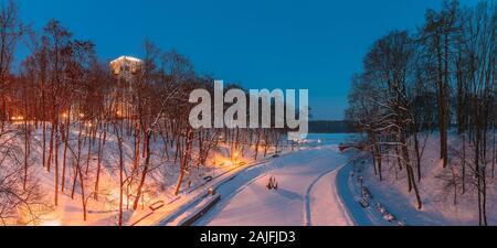 Gomel, Belarus. City Park im Winter Nacht. Clock Tower von Rumyantsevs und Paskeviches Palast und gefrorenen Teich im Park Homiel, Belarus. Berühmte lokale Lan Stockfoto