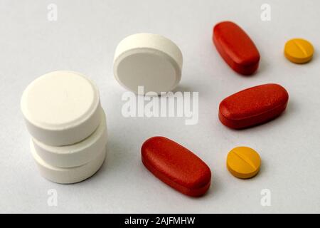 Mehrere Arten von Pillen oder Tabletten, vielleicht Narkotischen, Antibiotika oder Aspirin, auf hellen Hintergrund. Medizin und Pharmazie Konzept. Nicht isoliert. Close-up. Stockfoto