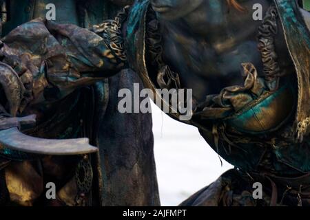 Details der lebende Statue von zwei Piraten. Frau und Mann in Bronze Kostüme mit Hüten und Waffen gekleidet darstellen als realistische menschliche Statue. Nahaufnahme Stockfoto