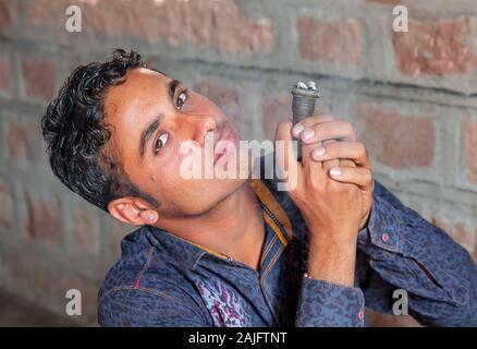 Jodhpur, Indien - 08.März 2017: Der Mensch zeigt, wie man das Rauchen Rohr verwenden. Stockfoto