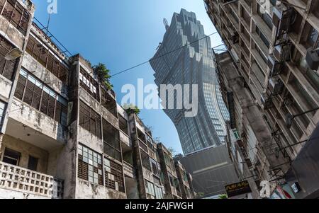 Macau, China: Der Grand Lisboa Casino Wolkenkratzer, Kontrast zwischen alten und neuen Gebäuden mit verfallenen Fassaden Stockfoto