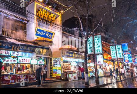 Xi'an, China: Geschäfte und beleuchtete Schilder bei Nacht in einer traditionellen Weg der Musselin Viertel in Xian (Xi). Städtische Szene, Street Food Stockfoto