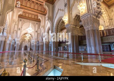 Casablanca, Marokko: Innenraum (gebetsraum) der Hassan II Moschee mit Säulen, Bögen und Kronleuchtern aus Murano-Glas. Islamische Architektur Stockfoto