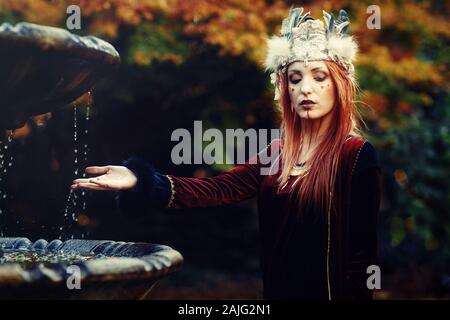 Schöne schamanische Frau mit Stirnband in der Natur. Stockfoto