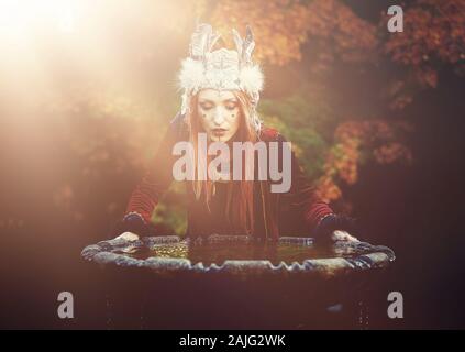 Schöne schamanische Frau mit Stirnband in der Natur. Stockfoto