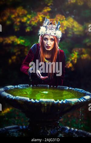 Schöne schamanische Frau mit Stirnband in der Natur. Stockfoto