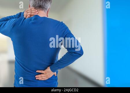 Ansicht von hinten Bild von einem alten Mann mit Hals- und Lendenwirbelsäule, am Krankenhaus Flur Stockfoto