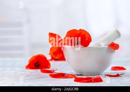 Keramik, Mörser und Stößel alternative Medizin Mohn Blumen vintage Hintergrund Stockfoto