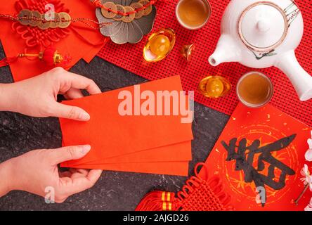 Design Konzept der Chinesischen Mondkalender Januar Neujahr - Woman Holding, die roten Briefumschläge (ang Pow, Hong Bao) für Glück, Geld, Ansicht von oben, flach, overhe Stockfoto