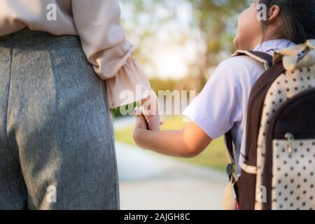 Nahaufnahme der Glücklichen asiatischen Mutter und Tochter im Vorschulalter Schüler zu Fuß zur Schule. Beginn der Unterrichtsstunden. Erster Tag der Fall. Elternschaft oder Liebe und Bondi Stockfoto