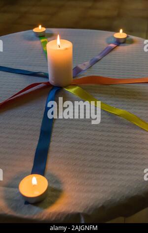 Kerzen aus, mit farbigen Kabelbindern auf einem Tisch mit weißer Tischdecke Papier Stockfoto