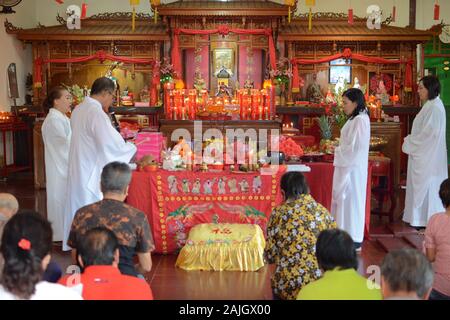 Eine Gruppe von Mönchen mit weißen Mänteln bereitet vor dem chinesischen Neujahrsfest eine Zeremonie in einem buddhistischen Tempel vor. Stockfoto