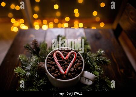 Hoher Winkel von Kaffeebohnen mit Weihnachtsbeleuchtung und Zuckerrohr Herz Stockfoto
