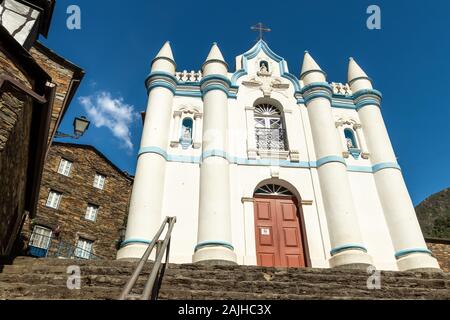 Igreja Matriz de Nossa Senhora da Conceição, die Schiefer Dorf Piodão, von der Einstiegspunkt in das Dorf gesehen, mit einem typischen Schiefer Haus. Stockfoto