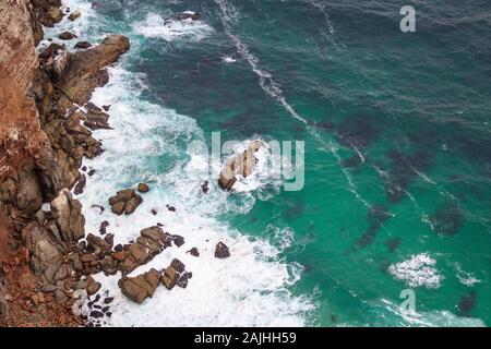 Luftaufnahme des türkisblauen Meer stürzt gegen steile Klippen, Kap der Guten Hoffnung, Südafrika Stockfoto