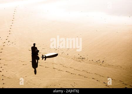 Blick von oben auf ein Surfer am Strand zu sitzen Stockfoto