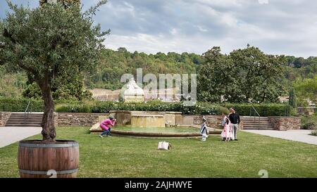 Die Fotografin nimmt eine ethnische Familienfeier mit Eltern und Kindern auf, die sich alle in feierlichen Outfits in Deutschland in der Nähe des Rheins kleiden. Stockfoto