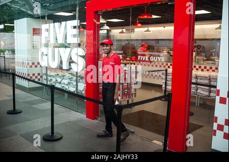 03.01.2020, Singapur, Republik Singapur, Asien-Mitarbeiter vor der ersten Fünf der Stadt Kerle Burger und Pommes frites Auslass der Fast-Food-Kette. Stockfoto