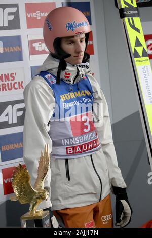 Innsbruck, Österreich. 04 Jan, 2020. Ski Nordisch/Skispringen: Weltcup, Vierschanzentournee, Big Hill, Männer, 2. Karl Geiger, Skispringer aus Deutschland, steht neben der Trophäe des Siegers, der Adler für den Gesamtsieger. Credit: Daniel Karmann/dpa/Alamy leben Nachrichten Stockfoto