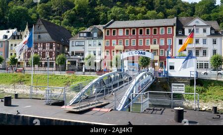 KD Rhine River Cruise Line Terminal mit historischem St. Goar Dorf mit bunten Häusern und Geschäften an der Flusspromenade, Deutschland. Stockfoto