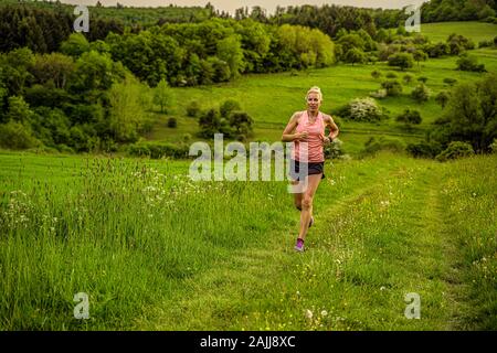 Eine Frau mittleren Alters läuft durch die Hügel Stockfoto