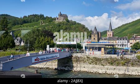 Blick auf den Rhein von KD Cruise Line Terminal und Schloss Stahleck hoch über dem mittelalterlichen Dorf Bacharach, Deutschland. Stockfoto