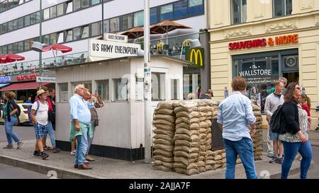 Touristen reflektieren über die historische Bedeutung des Checkpoint Charlie Station in der Innenstadt von Berlin, Deutschland. Stockfoto