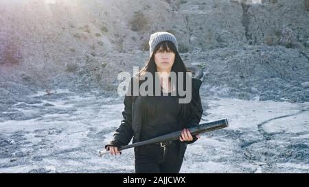 Brutale Frau von hooligan Banden geht mit einem Baseballschläger in der Einöde Stockfoto