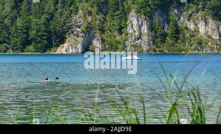 Menschen Schwimmen und Bootfahren auf dem Alpsee in Hohenschwangau beliebt bei Touristen wegen Märchen Schloss Neuschwanstein in der Nähe Stockfoto