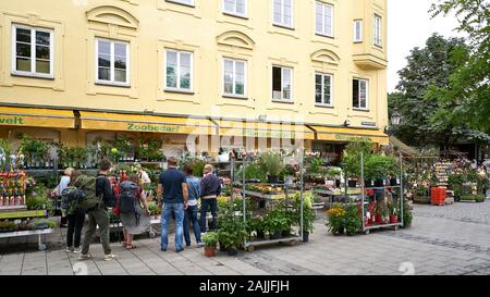 Menschen Einkaufen in einem kleinen Garten Einrichtung in der Mitte des berühmtesten Markt in München, Viktualienmarkt, einem berühmten Biergarten. Stockfoto