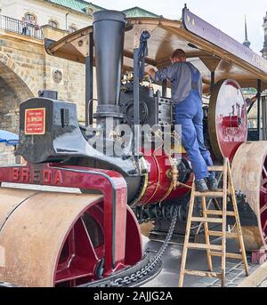 Vintage italienische Dampfbetriebene Dampfwalze oder Pflaster Rolle Maschine arbeitete auf durch den Menschen in der Zeit von Arbeitskleidung. Stockfoto